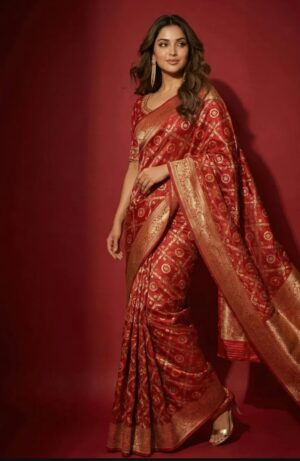 A timeless red Banarasi silk saree featuring traditional gold buti motifs and a richly woven zari border.