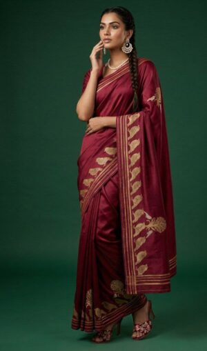 A striking maroon Banarasi silk saree enhanced with delicate zari motifs